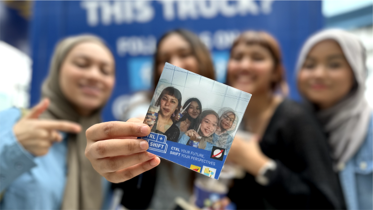 Four young women smile behind a hand holding a printed photo of them with text "Ctrl Your Future, Shift Your Perspectives."
